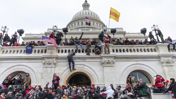 Rioters scaling the walls of the US Capitol building on 6 January 2021