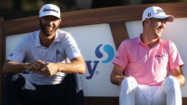 Dustin Johnson (L) and Justin Thomas share a laugh at the 18th tee