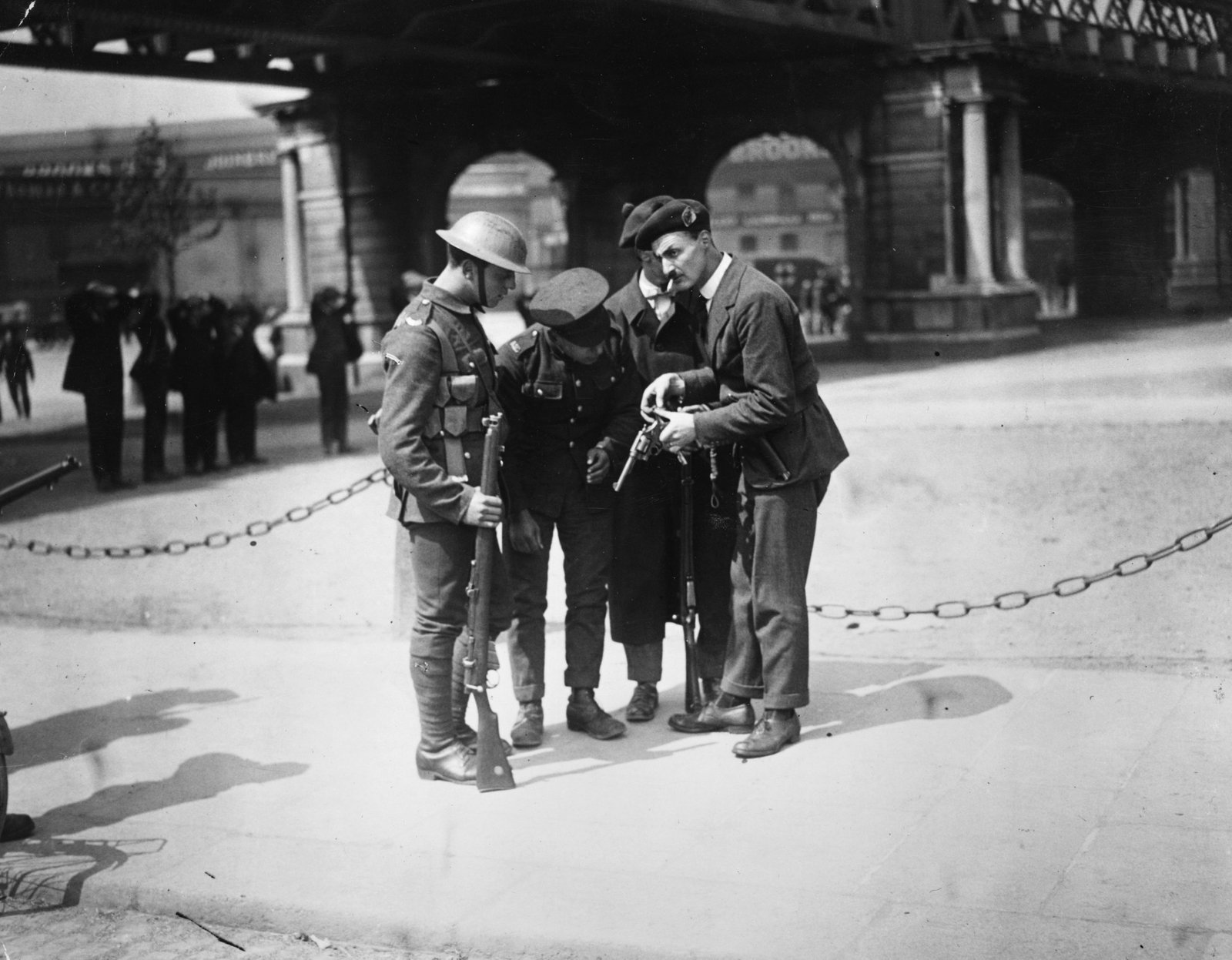 Image - British soldiers watch a Black and Tan reload his revolver outside the Custom House. Photo: Walshe/Getty Images