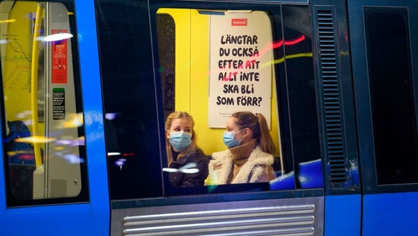 Passengers on an underground train wear masks in Stockholm