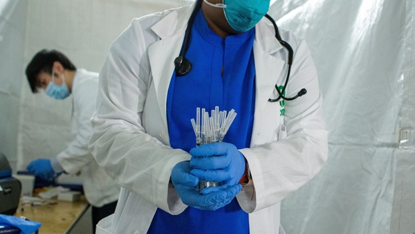 A health worker carries syringes to administer the Covid-19 vaccine at a vaccination site in Harlem, New York