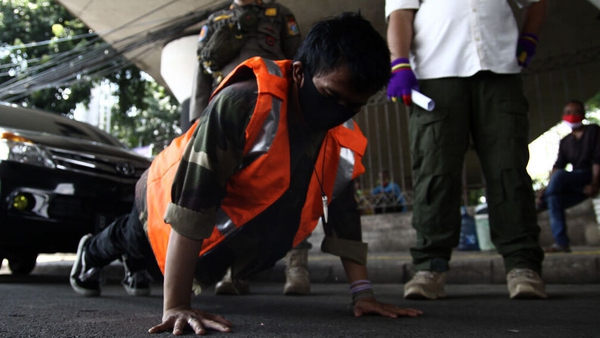 A resident does push-ups in May last year as a sanction for breaking large-scale social restriction regulations in Indonesia