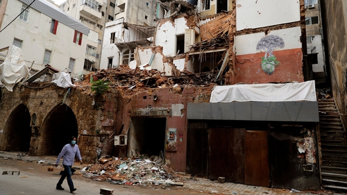 A man walks by a building damaged by the 4 August blast in Beirut's Gemayzeh neighbourhood