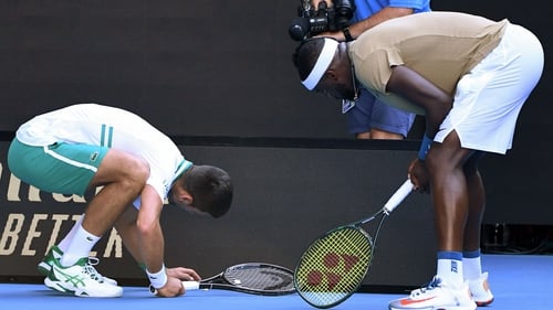 Novak Djokovic helps Frances Tiafoe find his vibration dampener at Rod Laver Arena