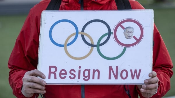 A man holds placard outside Japan Olympic Museum calling for the resignation of Yoshiro Mori.