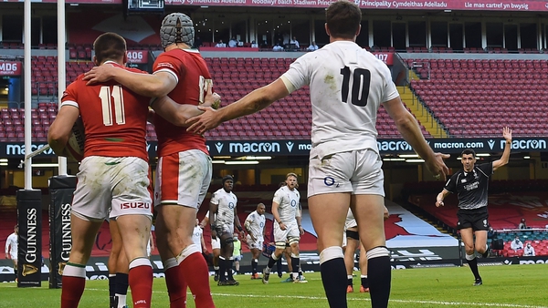 Wales' Josh Adams (L) is congratulated by Jonathan Davies as England's George Ford appeals to referee Pascal Gauzere