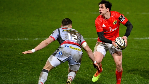Joey Carbery of Munster in action against Scarlets' Steff Hughes