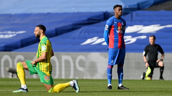 Wilfried Zaha stands as players and officials 'take the knee'