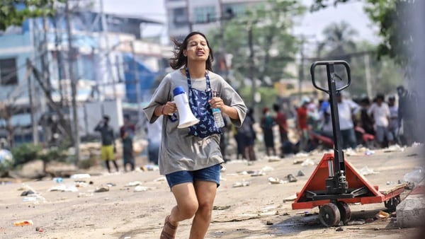 A woman holds a megaphone during a protest in Hlaing Tharyar township