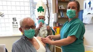 Dr Noreen Curtis vaccinating Clare Island resident Chris O'Grady, with St Patrick, aka Dr Paddy Lineen, watching on