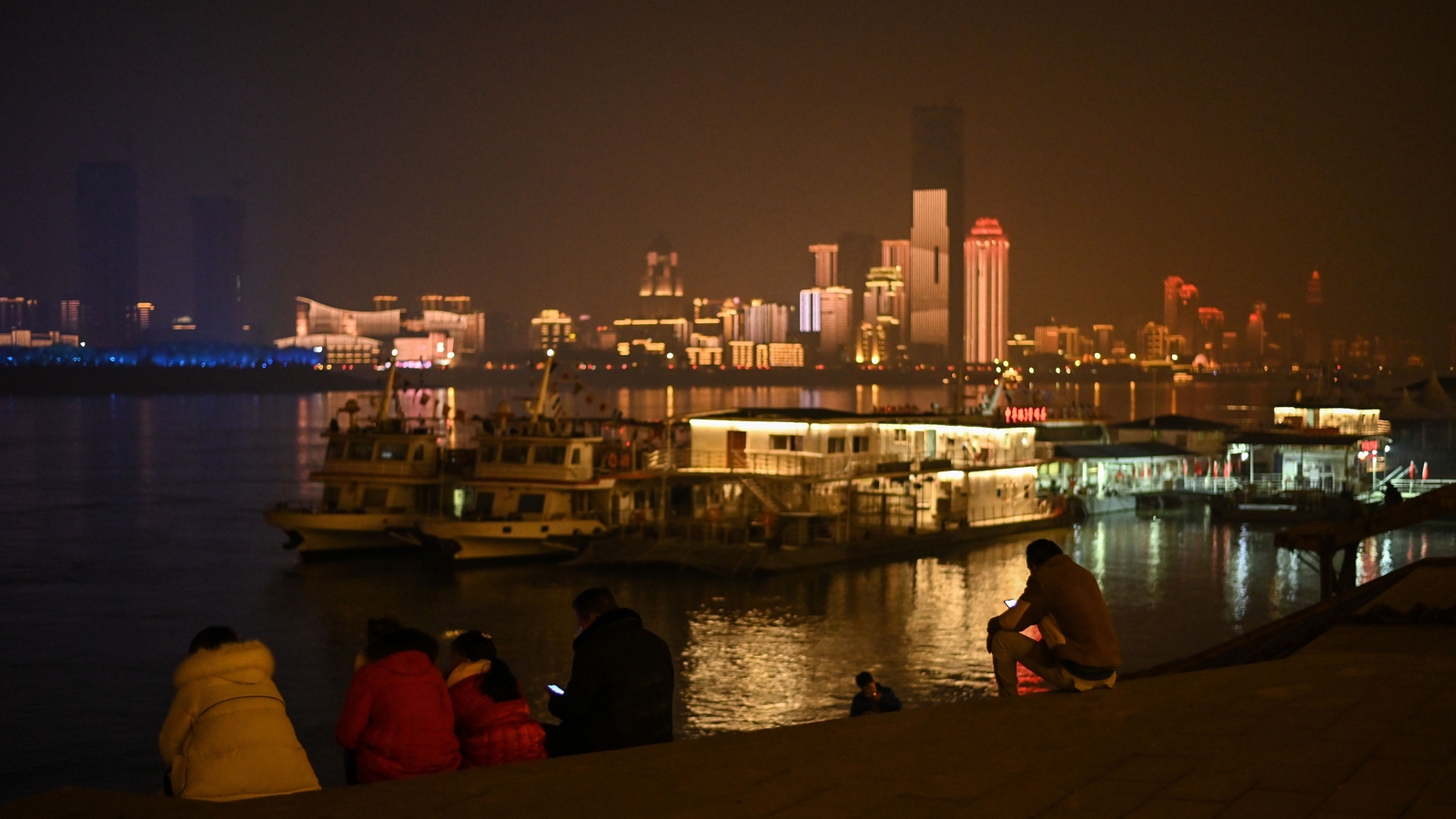 Image - People sit on the banks of the Yangtze River in the central Chinese city of Wuhan