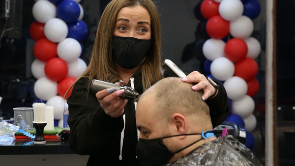 Barber Maggie McGillivray trims Sam Rosenblom's hair at Tony Mann's Barber Shop in Giffnock near Glasgow