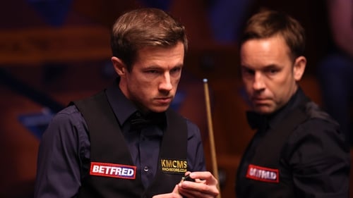 Jack Lisowski (L) chalks the cue as Allister Carter of England looks on