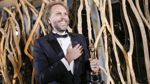 Florian Zeller smiles as he holds his Oscars statuette after winning the Best Adapted Screenplay for The Father