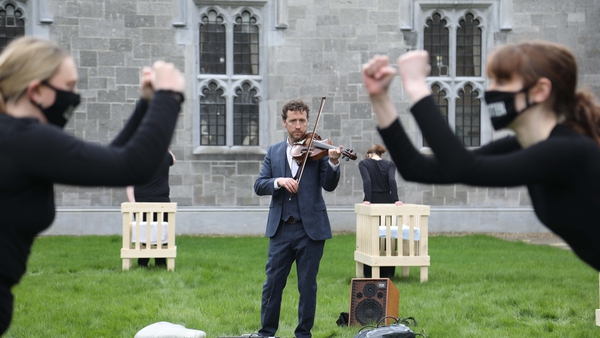 Colm Mac Con Iomaire plays the violin while students Leanne Anderson and Sarah Dooley perform to Emer's Dream inside the Quadrangle Building at NUI Galway. Photo: Aengus McMahon.