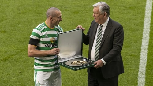 Celtic chief executive Peter Lawwell (R) presents Scott Brown with a commemorative silver plate