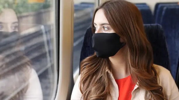 woman on a train wearing a mask