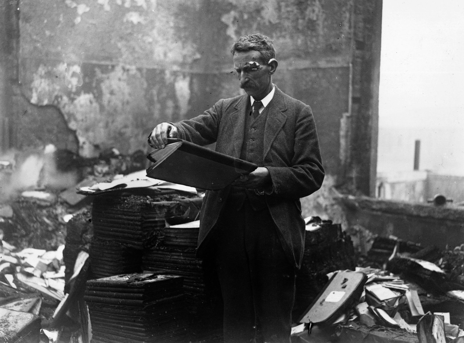 Image - A civil servant retrieves files from the destroyed building. Credit: Getty Images.