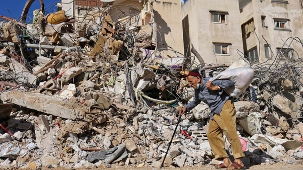 A man walks past a building destroyed by Israeli bombardment in Gaza City