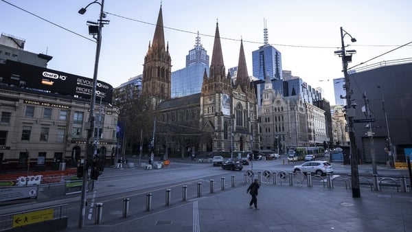 A person walks along a very quiet Flinders Street in Melbourne