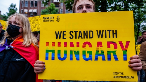 A man holds a placard during a demonstration against Hungary's Anti-LGBT Law in Amsterdam