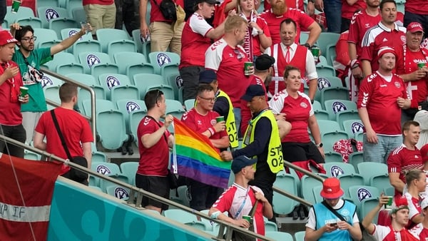 Stewards move in to confiscate a rainbow flag from a Denmark supporter in Baku