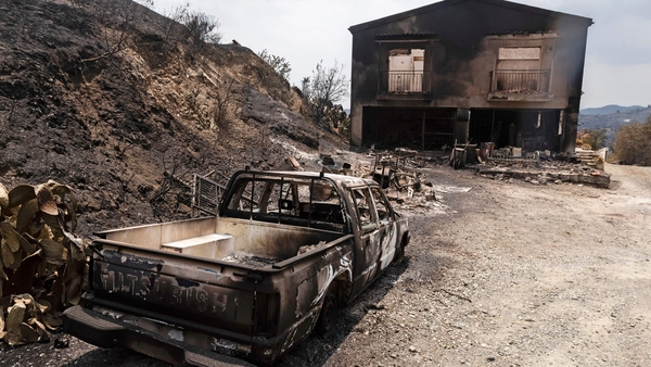 A burnt vehicle and house near Ora village on the southern slopes of the Troodos mountains