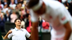 Hubert Hurkacz celebrates while Roger Federer slumps in the foreground