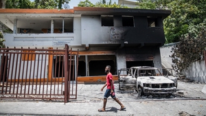 A charred car and building are pictured near the Petionville police station, where suspects in the assassination of President Jovenel Moise are being held