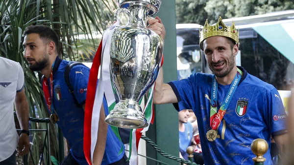 Italy's captain Giorgio Chiellini (R) carrying the trophy as his team arrives at Parco dei Principi hotel in Rome this morning