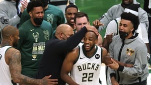 Khris Middleton is congratulated by Bucks team-mates during the second half