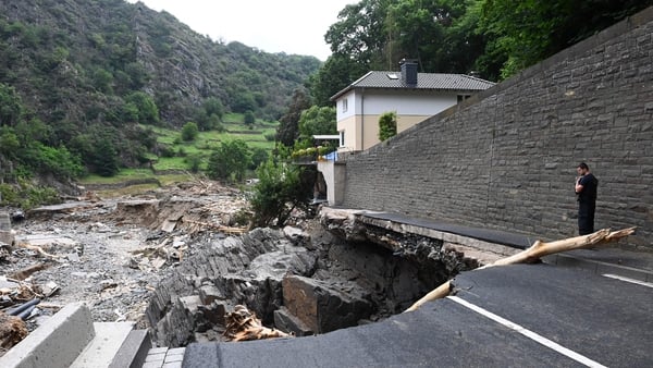 A policeman looks at a piece of road that was washed away in the city of Altenahr in Rhineland-Palatinate