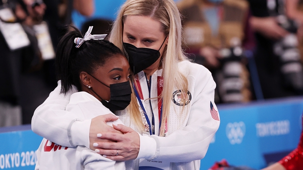Simone Biles is comforted after pulling out of the women's team final