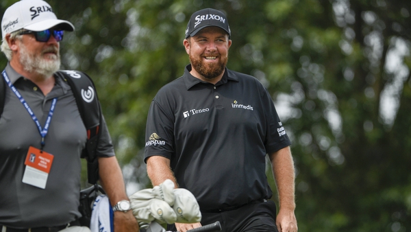 Shane Lowry smiles on his way to the 10th tee