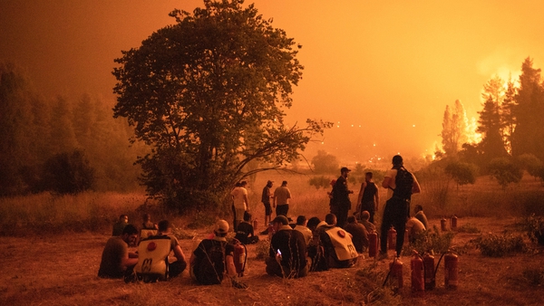 Locals watch a wildfire outside the village of Kamatriades, Greece, in August 2021