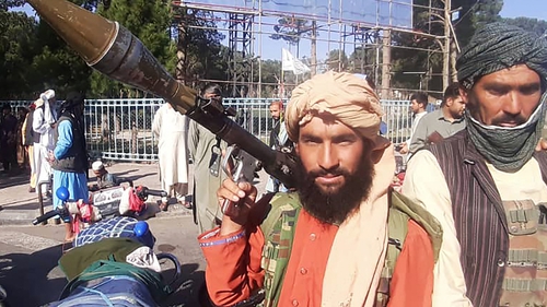 A Taliban fighter holds a rocket-propelled grenade along the roadside in Herat in Afghanistan