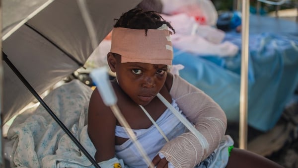 A boy is tended to outside Les Cayes General Hospital after a 7.2-magnitude earthquake struck Haiti