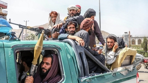 Taliban fighters are seen on the back of a vehicle in Kabul today
