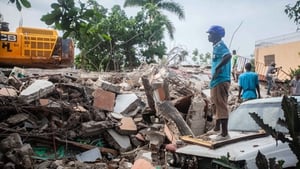 Rescue workers search for survivors among the debris of collapsed houses in the city of Les Cayes