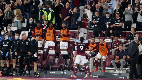 Michail Antonio holds up a cardboard cutout of himself as he celebrates with West Ham fans