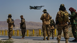 A C-17 Globemaster takes off as Taliban fighters secure the outer perimeter of Kabul airport, as America controlled inside the fence