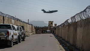 A plane takes off as Taliban fighters secure the outer perimeter, alongside the US controlled side of Kabul airport