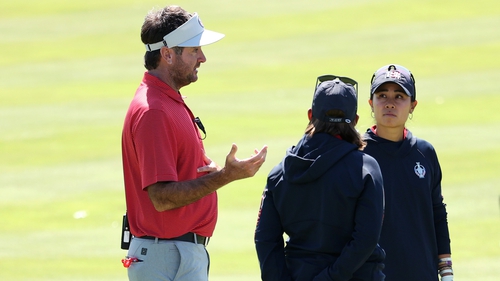 Bubba Watson talks with Danielle Kang of Team United States during a practice round ahead of the start of The Solheim Cup at Inverness Club