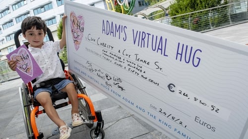 Adam King with a cheque for €266,830.52 to be split equally between two hospitals
