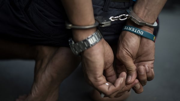 An alleged drug dealer is captured by policemen after a drug buy-bust operation on a slum area in Manila in September 2017