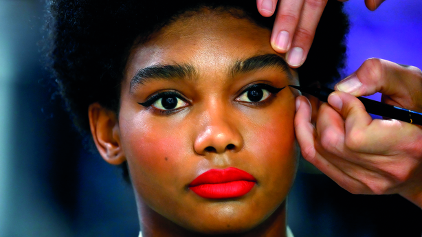 A model gets her makeup done backstage prior to the presentation of Spanish designer Agatha Ruiz de la Prada's Autumn - Winter 2021 / 2022 collection during the Mercedes Benz Fashion Week in Madrid on April 9, 2021