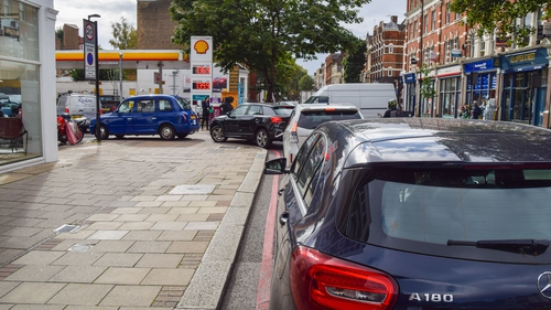 Cars are seen queuing at a fuel station in London