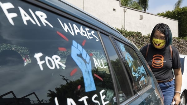 Crystal Kan, a storyboard artist, draws pro-labour signs on cars of union members during a rally at the Motion Picture Editors Guild IATSE Local 700 on September 26 in Los Angeles, CA (Myung J. Chun / Los Angeles Times via Getty Images)