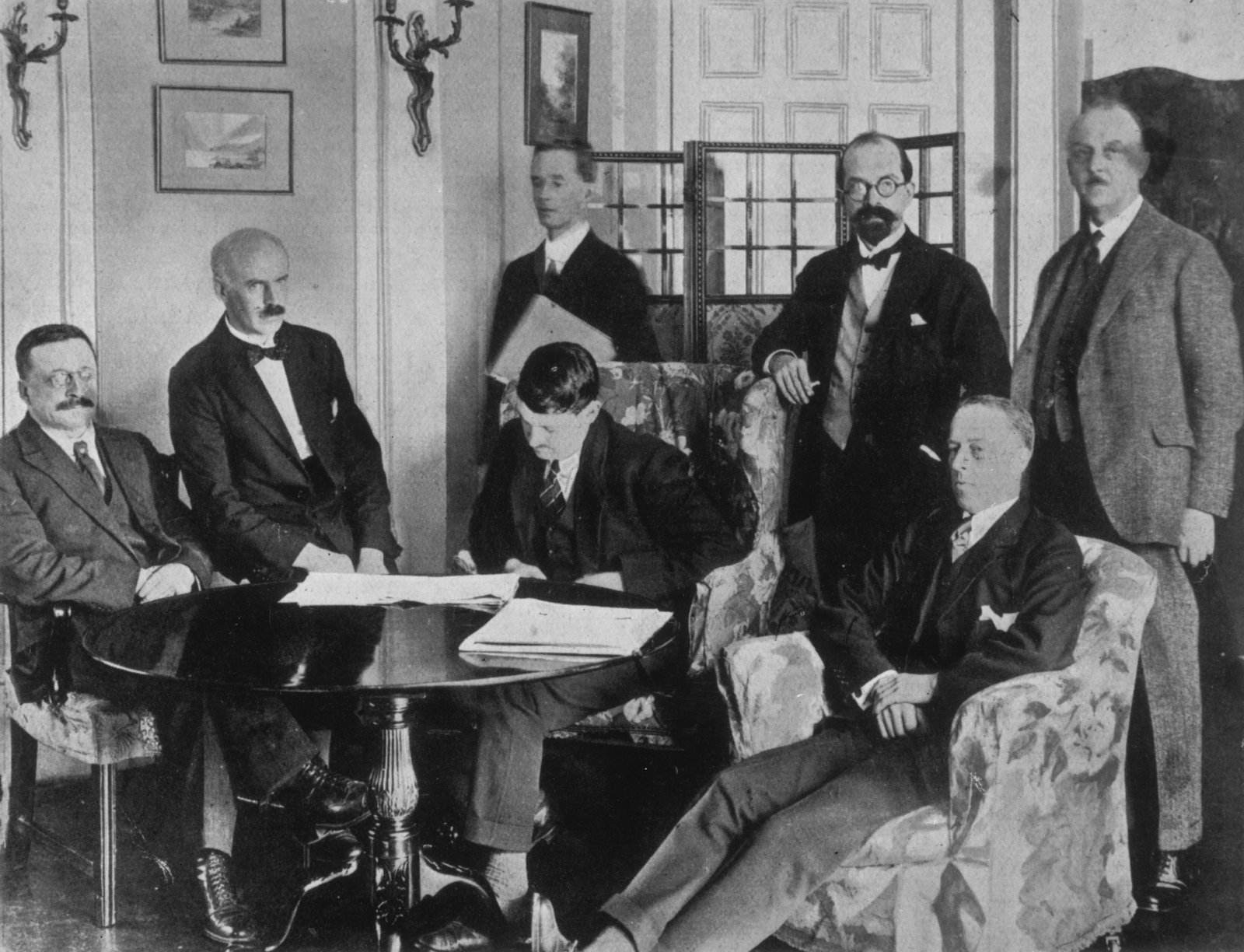 Image - This photo is claimed to capture the moment the Irish delegates began signing the treaty (Credit: Getty Images)