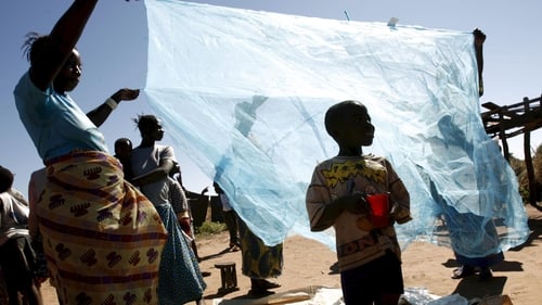 A file picture shows villagers looking at new mosquito nets donated to try to fight high malaria in their village, Matongo, Zambia